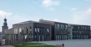 Plombier Gembloux devant l'hôtel de ville historique, façade en briques et ardoises typique du centre urbain belge