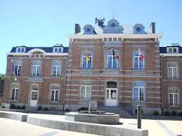 Rue animée à Jemeppe-S-Sambre avec camion de débouchage, devant bâtiments en briques rouges typiques. Débouchage Jemeppe-S-Sambre