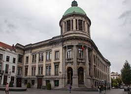 Plombier Molenbeek Saint Jean devant façade colorée de la Maison Communale, typique rue pavée et architecture locale