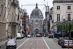 Plombier Saint Josse Ten Noode rue animée avec bâtiments typiques, enseignes colorées et passants du quartier élégant.