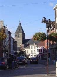 Scène urbaine de Tubize avec rues pavées animées, bâtiments anciens et camion de débouchage en intervention locale.