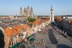Plombier Wavre dans une rue pittoresque bordée de maisons traditionnelles et d'un bâtiment historique en brique rouge.