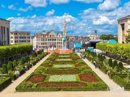 Plombier Woluwe Saint Lambert au travail près du parc Georges Henri, scène typique avec immeubles modernes en arrière-plan